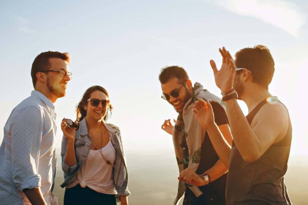 Group of young adults enjoying a sunny day outdoors, laughing and walking together