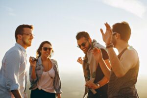 Group of young adults enjoying a sunny day outdoors, laughing and walking together